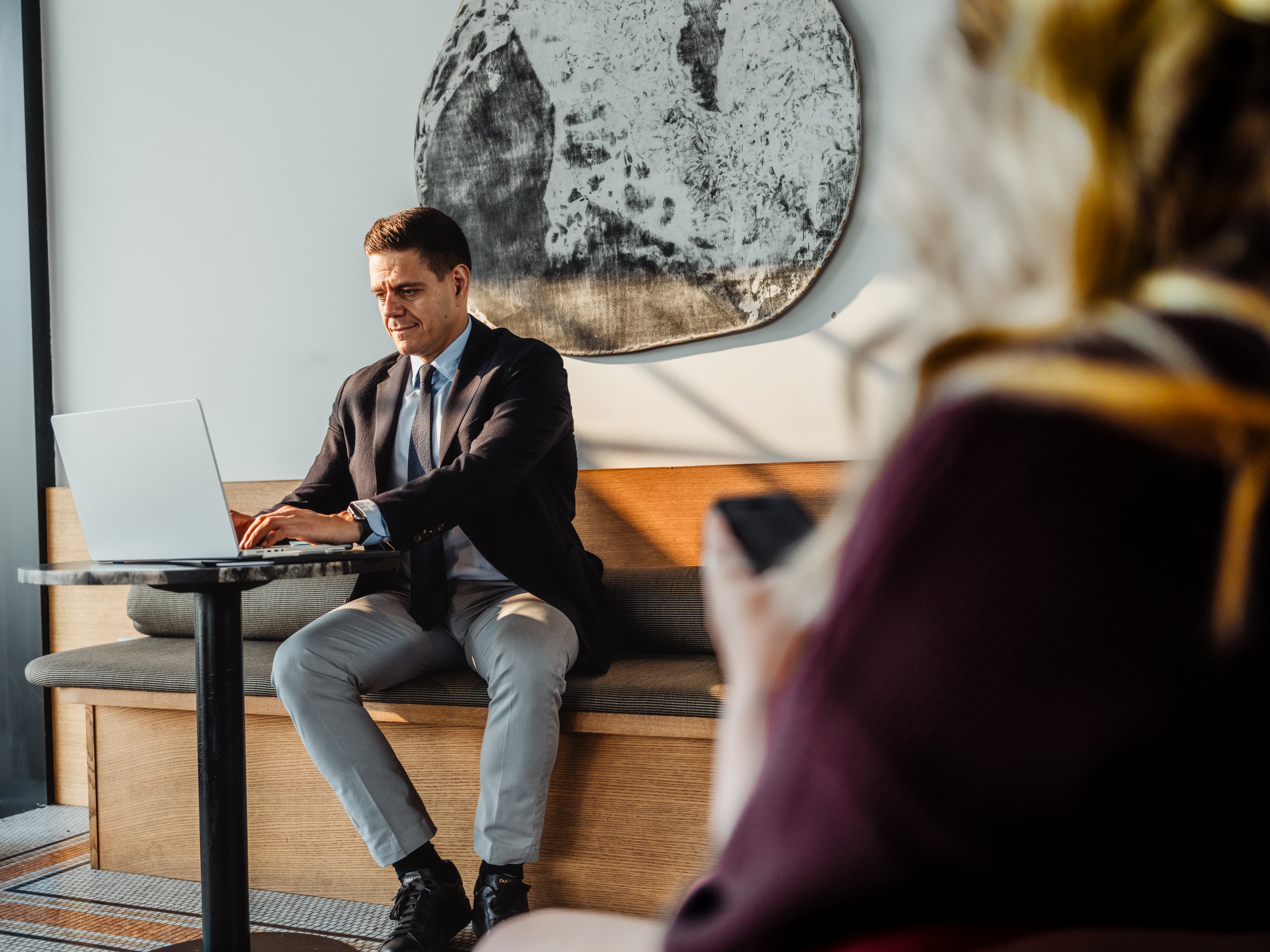 Man sitting at a table typing on a laptop