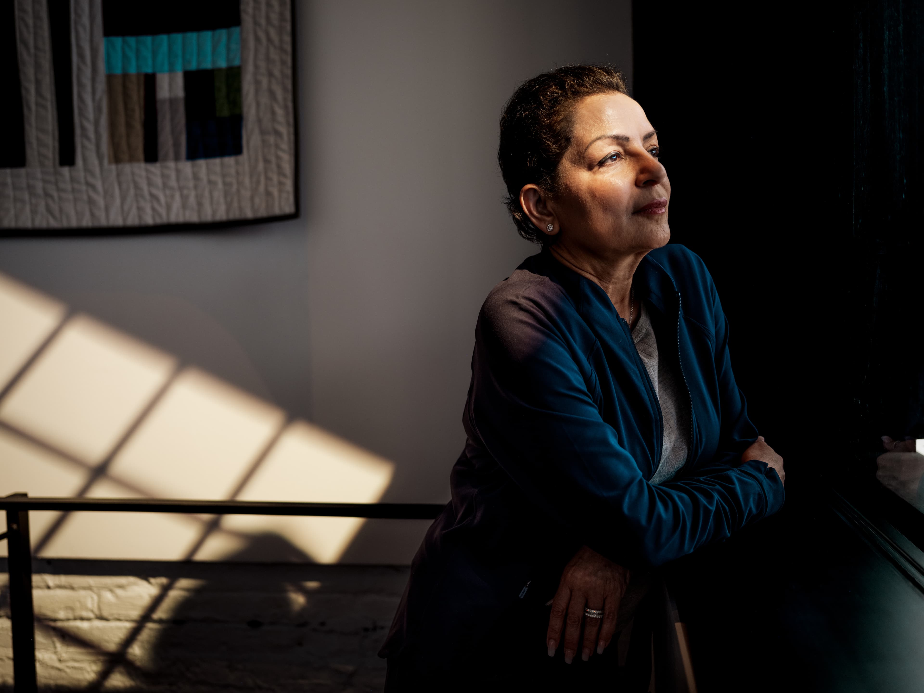 Woman leaning on a office windowsill, looking out
