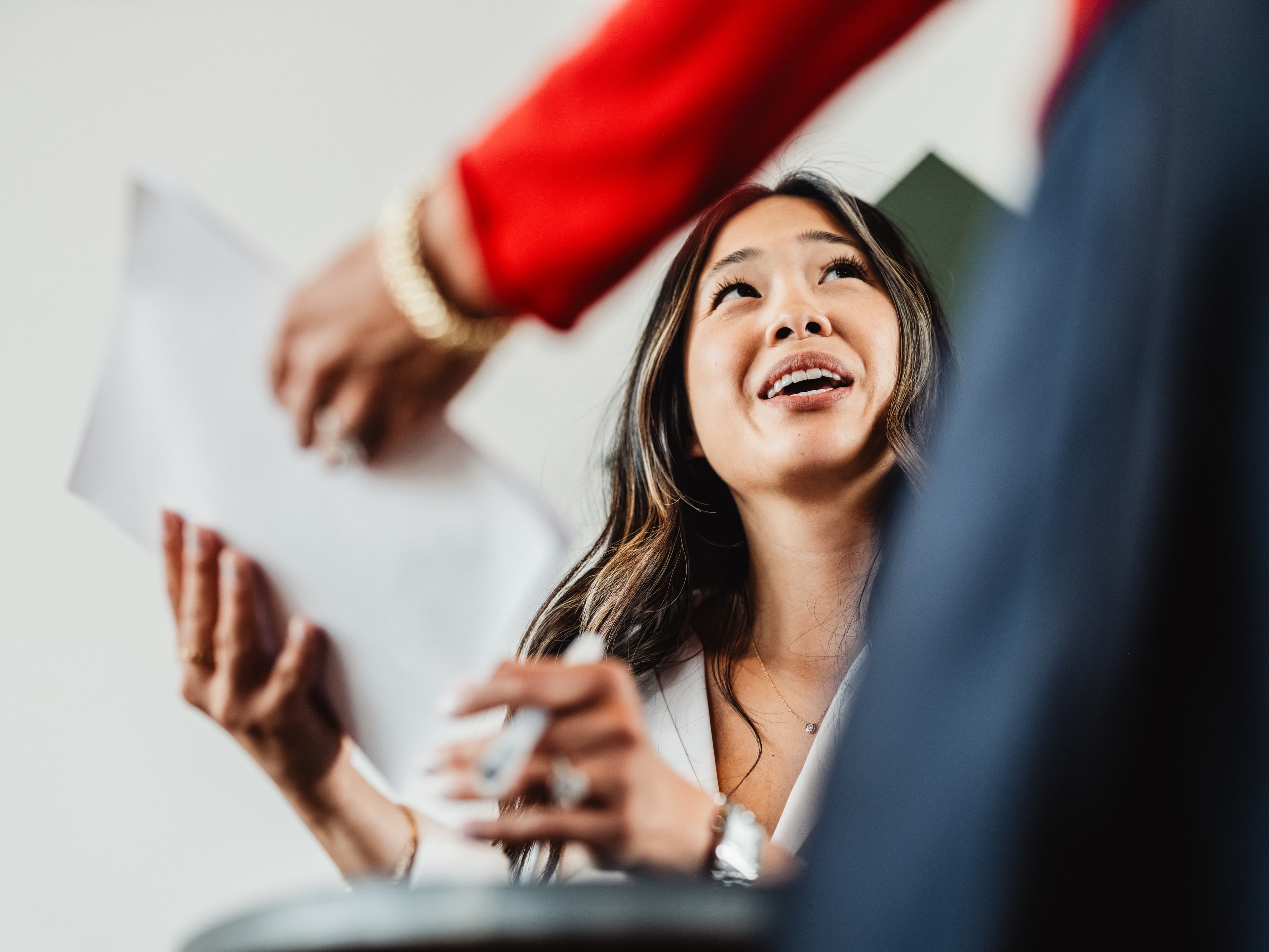 Woman handing a piece of paper to coworker